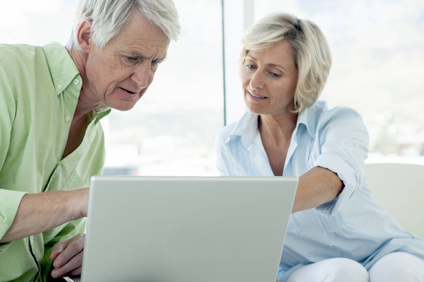 beautiful senior couple using computer together at home  - Foto, Imagen