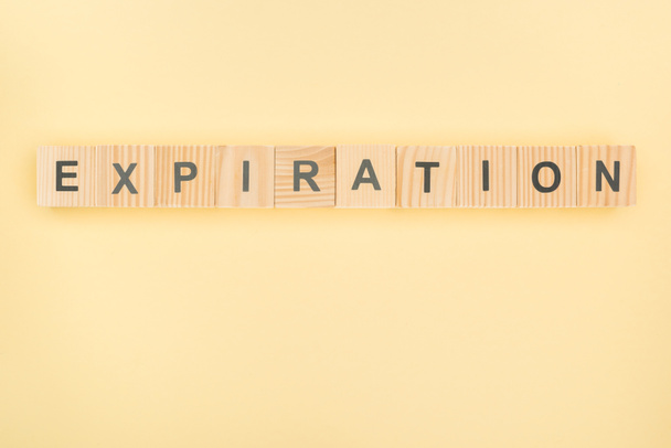 top view of expiration lettering made of wooden blocks on yellow background - Photo, Image