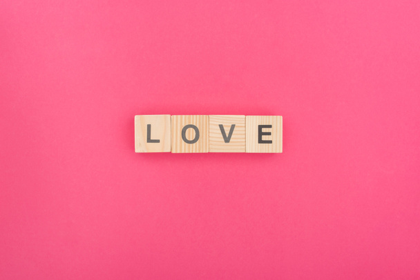 vue du dessus des lettres d'amour en blocs de bois sur fond rose
 - Photo, image
