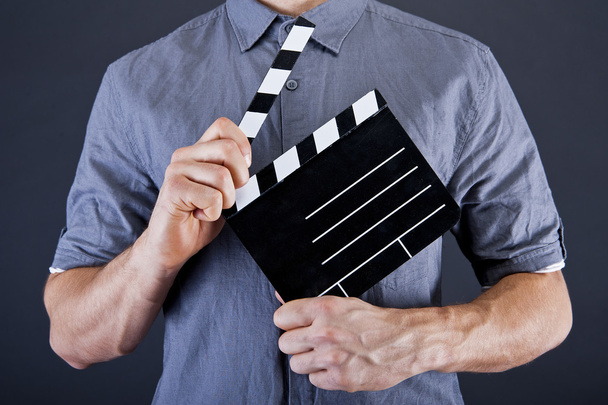άνθρωπος με χειροκρότημα ταινία πάνω από το σκούρο φόντο - Φωτογραφία, εικόνα