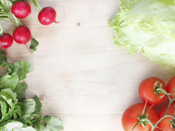 Fresh vegetables on a wooden board - radishes, lettuce, arugula, tomatoes - Photo, Image