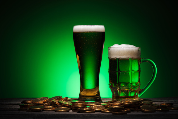 bicchieri di birra verde vicino monete d'oro su sfondo verde
 - Foto, immagini
