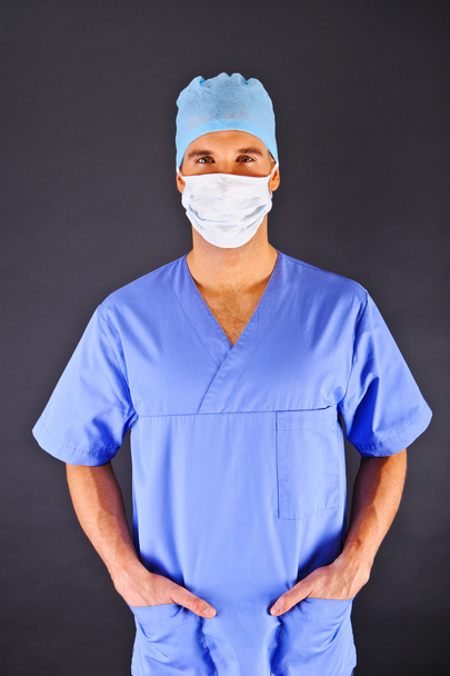 Doctor sobre fondo oscuro en camisa azul
 - Foto, imagen