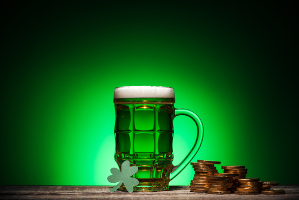 sklo zelené Irské pivo u zlatých mincí a krychle kalendář na zeleném pozadí - Fotografie, Obrázek