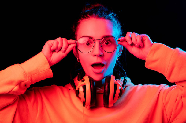 Moda mujer bonita con auriculares escuchando música sobre fondo de neón
 - Foto, imagen