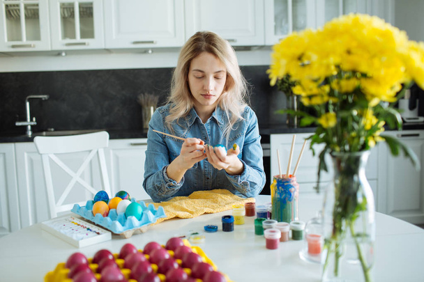 Girl paints eggs for easter - Foto, afbeelding