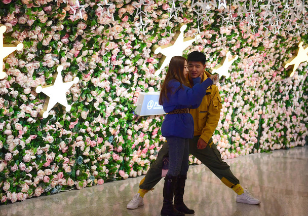 Пара закоханих прогулянки по тунелю прикрашені квітами напередодні Дня Святого Валентина в Шеньян, Північно-Східної Китаю провінції Ляонін, 12 лютого 2019. - Фото, зображення