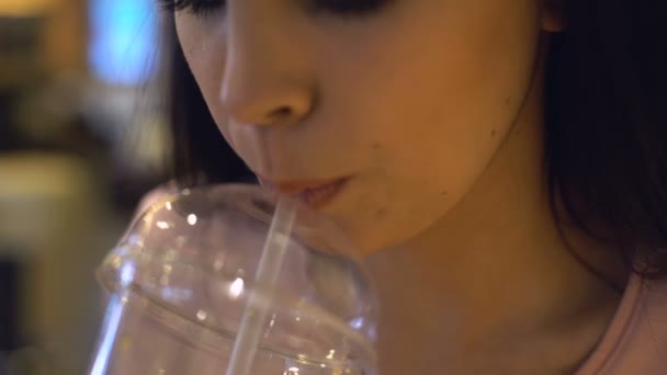 Női tinédzser iszik gyümölcs koktél, műanyag pohár, és mosolyogva friss bar - Felvétel, videó
