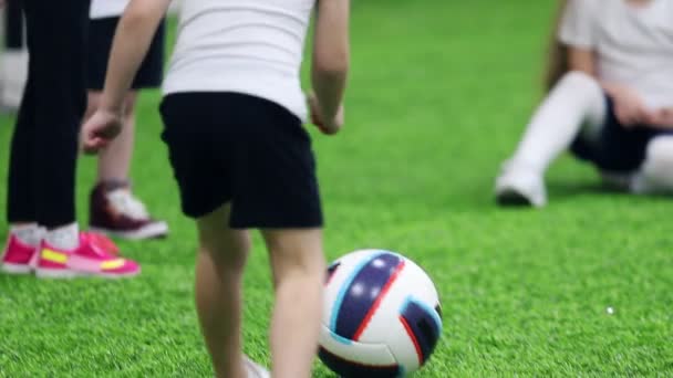 Fußball-Hallen. Kleines Kind tritt gegen den Ball und Mädchen fängt ihn mit den Händen - Filmmaterial, Video