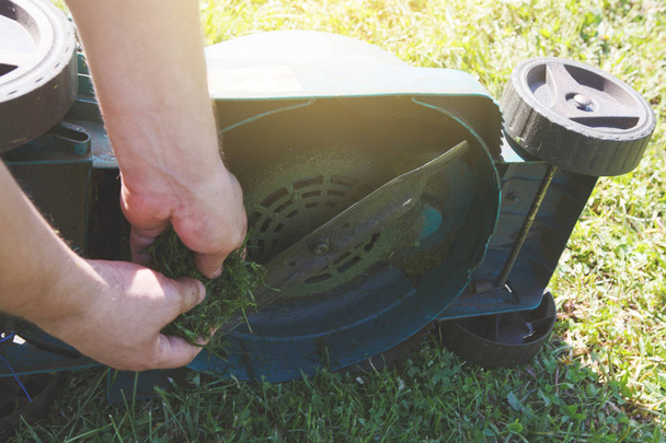 садовник стрижет зеленую траву электрическая газонокосилка, избирательный фокус
 - Фото, изображение