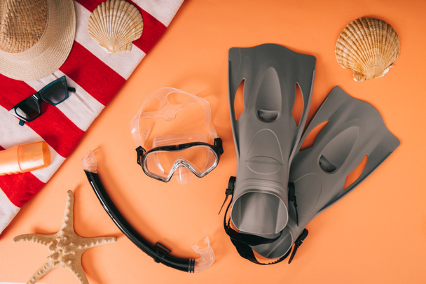 top view of summer accessories and diving equipment on orange background with seashells - Photo, Image