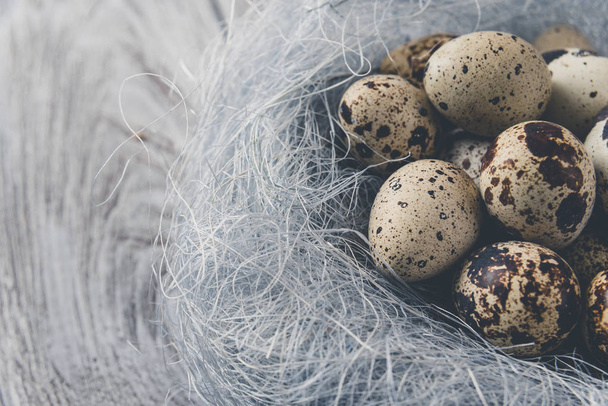 Easter decoration. Quail eggs in a nest on a wooden background - Foto, Imagem