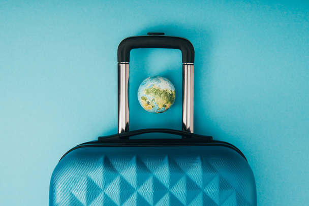 vista superior del modelo de globo y la bolsa de viaje sobre fondo azul
 - Foto, Imagen