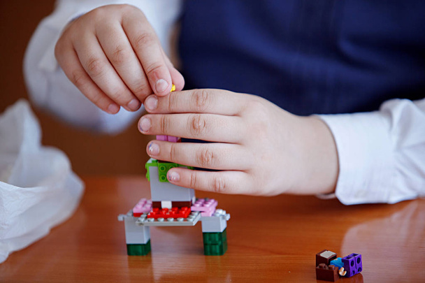 Schoolchildren play in building kit plastic blocks at a lesson in primary school - Photo, Image