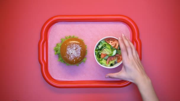 Hands taking hamburger and salad from plastic tray, student lunch in canteen - Filmmaterial, Video