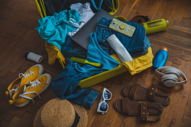 concept de voyage. valise jaune avec différentes choses autour. vue de dessus
 - Photo, image