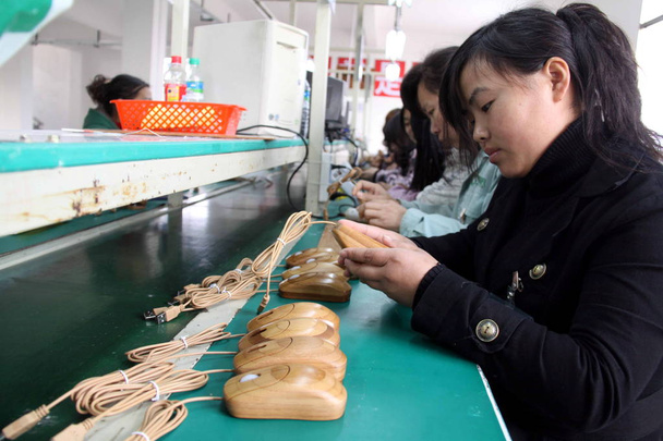 Chinese arbeiders monteren bamboe-en-klare computermuizen in de fabriek van Jiangxi bamboe technologie Develoopment Co., Ltd. in Tonggu county, Yichun stad, Oosten Chinas Jiangxi provincie, 22 februari 2010 - Foto, afbeelding