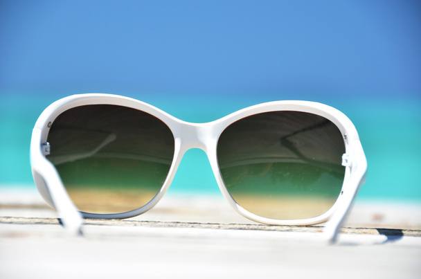 Óculos de sol contra o oceano tropical
 - Foto, Imagem