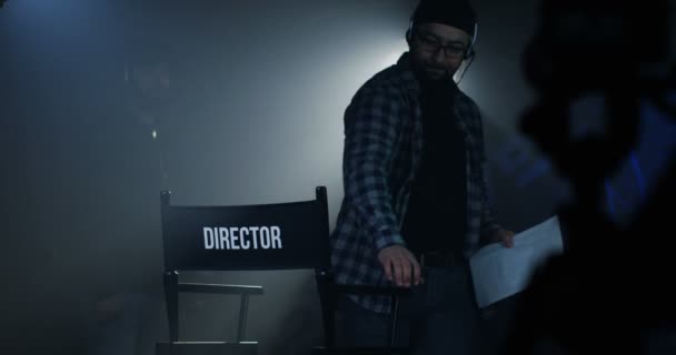 Regisseur sitzt auf seinem Stuhl am Filmset - Filmmaterial, Video