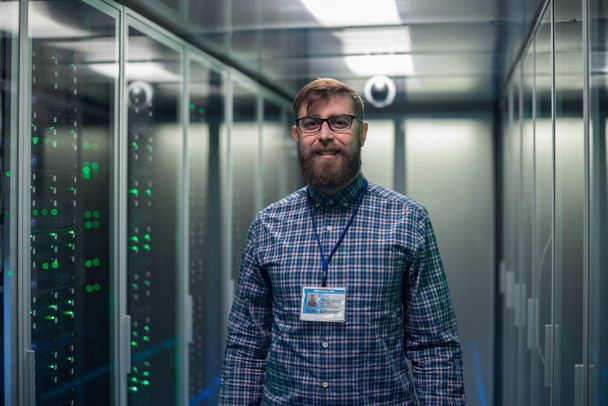 Adult bearded engineer in server room - Photo, Image
