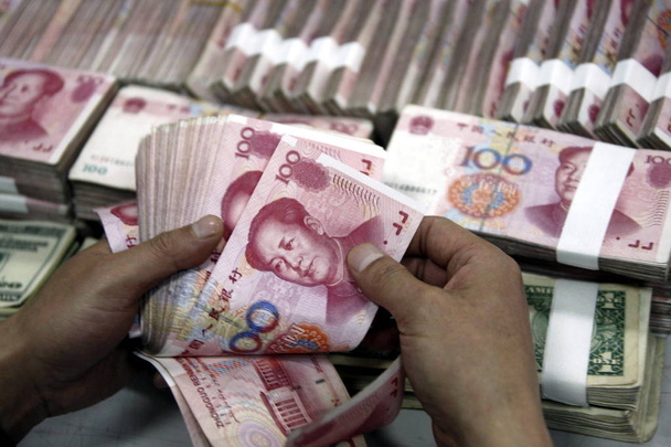 Um funcionário do banco chinês conta notas de RMB (Renminbi) yuan em um banco na cidade de Huaibei, leste da província de Chinas Anhui, 22 de abril de 2010
 - Foto, Imagem