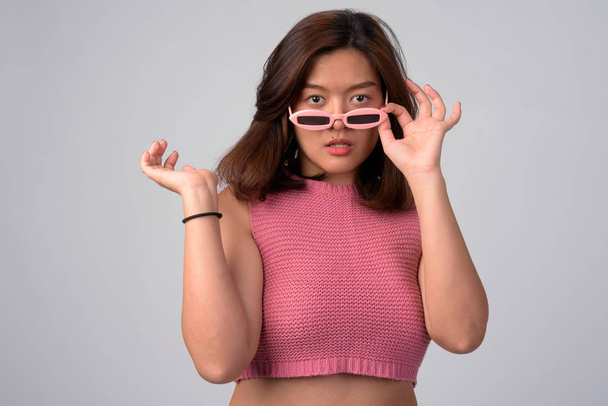 Retrato de joven hermosa mujer asiática quitando gafas de novedad
 - Foto, imagen