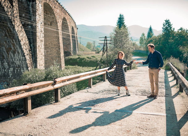 summer love story of Man and woman walk on the old railway in mountains - Photo, Image
