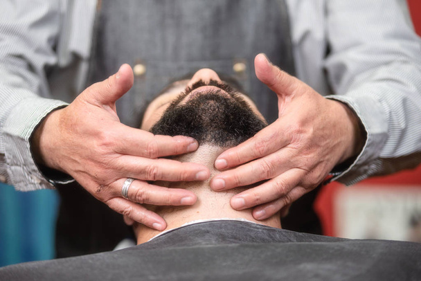 Стиліст зачіски наносить після гоління лосьйону в перукарні
. - Фото, зображення