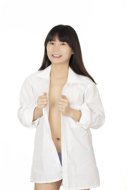 Beautiful Chinese woman dressed in a blue thong and white shirt isolated on a white background - 写真・画像