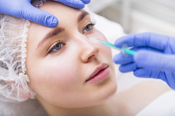 Woman receiving beauty plastic injection on her nose - Zdjęcie, obraz