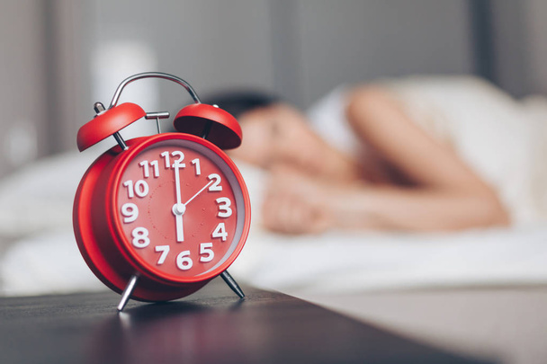 Alarm clock closeup and Young sleeping woman - Foto, Bild