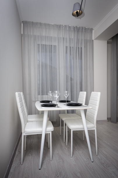 Moderno soggiorno bianco e grigio con tavolo da pranzo
 - Foto, immagini