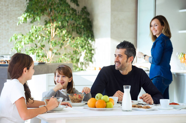 Shot of happy family eating breakfast and having fun in kitchen table at home. - Photo, Image