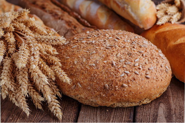 Assortiment gebakken brood op houten tafelondergrond - Foto, afbeelding