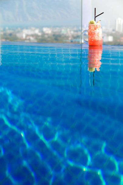 Kuva Fruit cocktail uima-altaalla näkymät kaupunkiin
 - Valokuva, kuva