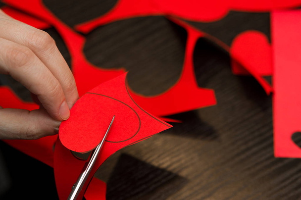 Γυναικεία χέρια απασχολημένος με καρδιές χαρτί cut-outs-ημέρα του Αγίου Βαλεντίνου.  - Φωτογραφία, εικόνα