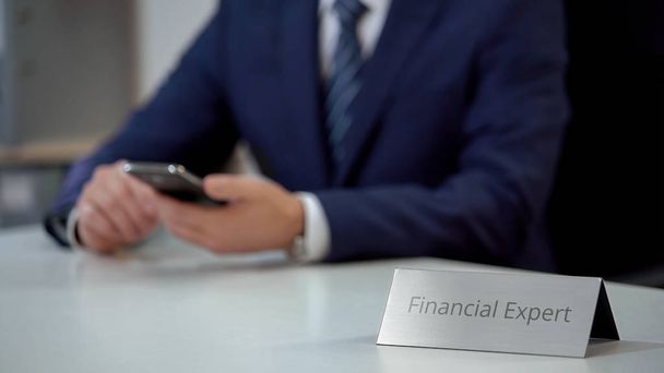 Financial expert using mobile app on smartphone, analyzing situation on market - Фото, изображение