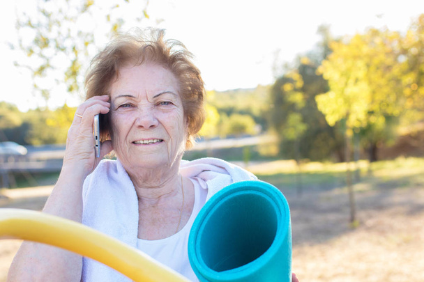 starszy kobieta z telefonem komórkowym robi Sport - Zdjęcie, obraz