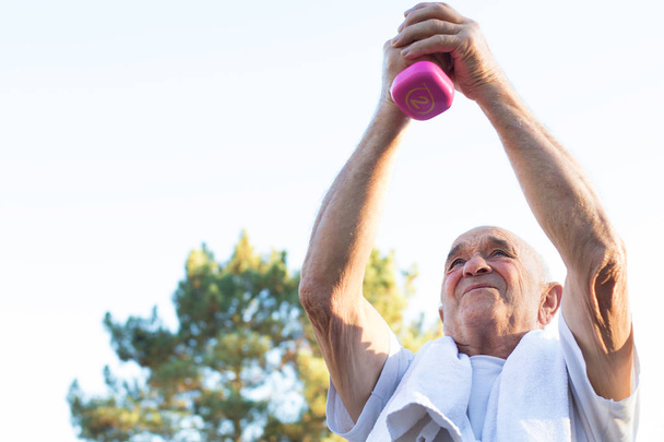 hombre mayor levantando la mancuerna haciendo ejercicio
 - Foto, imagen