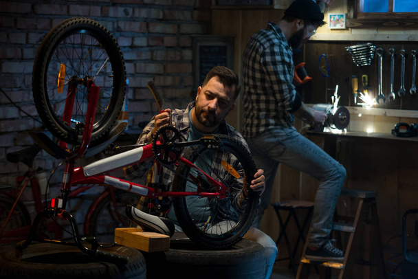 Dwóch mężczyzn pracujących w warsztat rowerowy - Zdjęcie, obraz