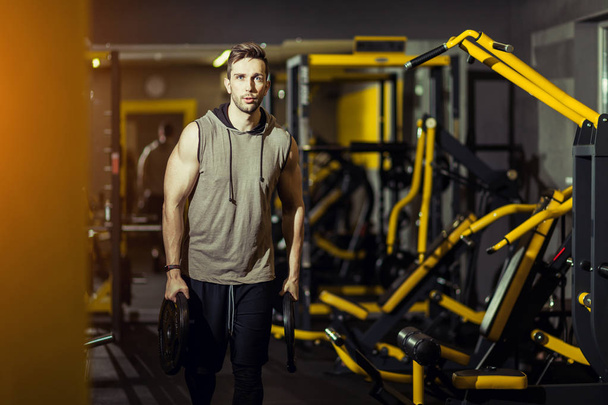 Concept Power Strength Healthy Lifestyle Sport Powerful Muscular man working out in gym doing exercises at lunges with weight disks - Fotografie, Obrázek