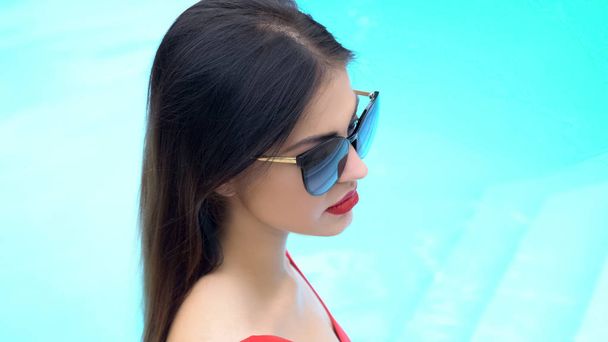 Sexy woman in eyeglasses standing against blue background, summer relaxation - Φωτογραφία, εικόνα