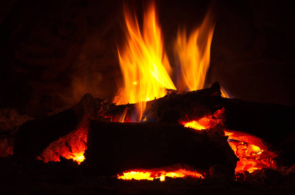 fogo queima muito brilhantemente em uma lareira e dá calor
 - Foto, Imagem