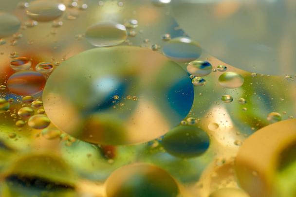 drijvend in het water abstract kleurrijk, druppels lichtgele olie - Foto, afbeelding