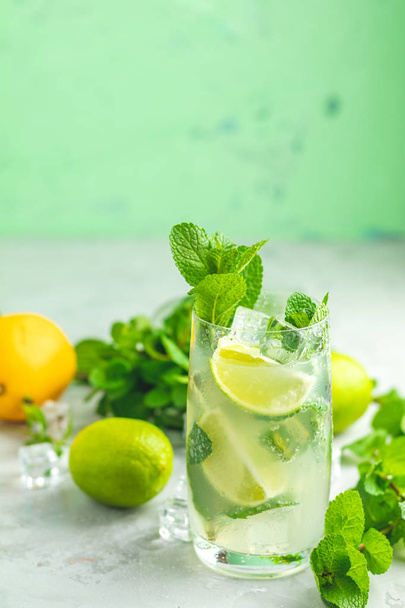 Mojito-Cocktail mit Limette und Minze im Highball-Glas auf grauem und grünem Betonsteinhintergrund. mit Kopierraum für Ihren Text - Foto, Bild