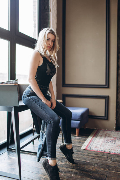 Portrait of a beautiful fashion woman, blonde, jeans, gray background - Fotó, kép