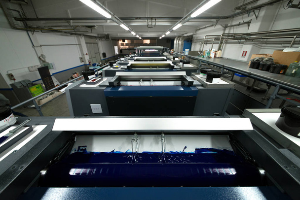 Imprensa de impressão - Máquina de compensação. Técnica de impressão em que a imagem com tinta é transferida de uma placa para uma manta de borracha e, em seguida, para a superfície de impressão
. - Foto, Imagem