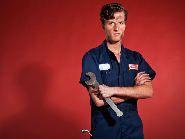 Retro fifties male car mechanic holding tool. Studio shot. - Foto, Imagen