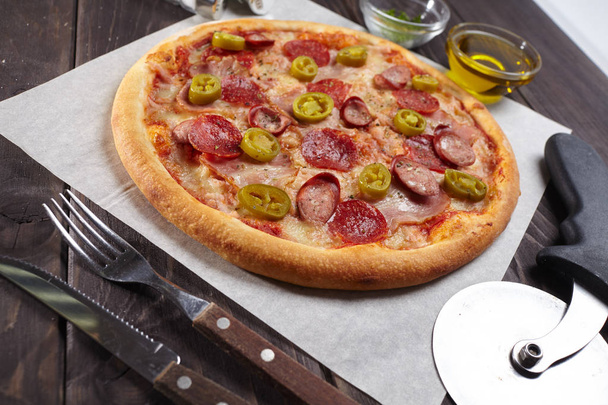 pizza sabrosa caliente con salchichas y rodajas de pimiento verde, primer plano
  - Foto, Imagen