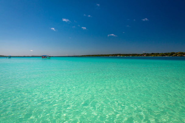 Die Laguna de Bacalar ist auch als Lagune der sieben Farben in Bacalar, Mexiko, bekannt. Das kristallklare Wasser und der weiße Sandboden des Sees bewirken, dass sich die Wasserfarbe im Laufe des Tages in verschiedene Schattierungen von Türkis, Blau und tiefem Indigo verwandelt. - Foto, Bild